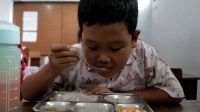 Seorang Anak Menikmati MBG Seorang Anak Menikmati Makanan MBG
